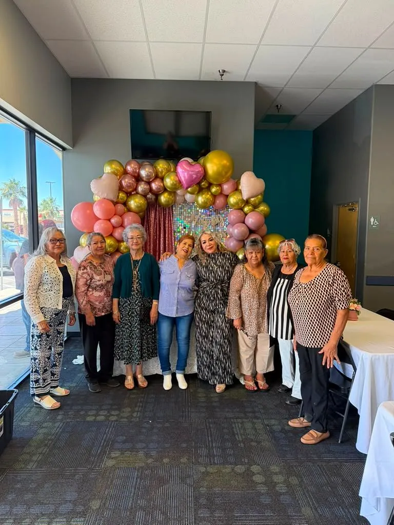 Clientas mayores en un evento de agradecimiento con arco de globos, El Paso